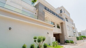 Un edificio moderno con el nombre "KACEM PALACE" en la fachada.