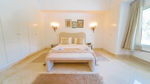 A bedroom with a large bed, two bedside tables, a nightstand, a chest of drawers, and a window with curtains. - La Marina: secure seaside with pool (La Marsa)