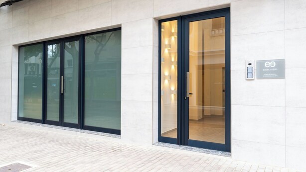 Ein modernes Gebäude mit großen Glasüren und einem Schild für EREZA SUITES.