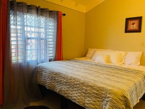 A room with a bed, a window with curtains, and a framed picture on the wall. - 3 King Beds Drax Hall~Pool~Gym~Gated~Full Air Con (Draxhall)