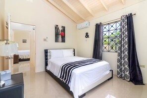 A bedroom with a bed, a bedside table, a mirror, a window with curtains, and a wall-mounted air conditioner. - 5 BedRmOasis DraxHall~Pool~Gym~ (Saint Ann's Bay)