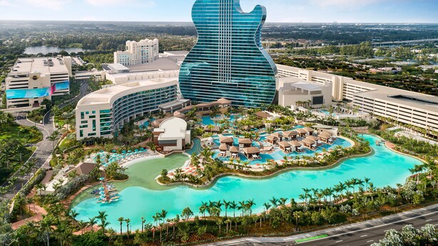 A resort with a guitar-shaped building, a large pool, and multiple guest rooms. - Luxury Suite • Studio with Kitchen & Spa Shower (Miramar)