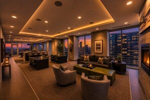 En modern hotellobby med en matplats, sittplatser, en öppen spis och utsikt över staden.