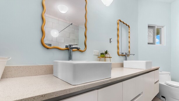 A modern bathroom with a large vanity, two sinks, a shower, and a toilet. - Teal Horizon~OceanfrontCaribbean Escape~Tower Isle (Tower Isle)