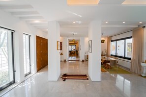 A spacious, modern interior with a central hallway leading to a dining area. - Villa Jar – Élégance et authenticité (La Soukra)