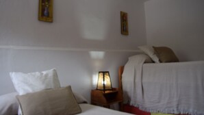 A hotel room with two beds, a nightstand with a lamp, and two wall-mounted paintings. - Rural House Parajes del Chanza (Cortegana)