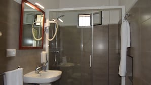 A modern bathroom with a glass shower enclosure, a sink, and a mirror. - Rural House Parajes del Chanza (Cortegana)