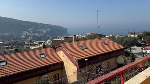 A coastal town with terracotta-roofed buildings, a prominent antenna, and a view of the sea. - Vacation home Sorrento Peninsula (Vico Equense)