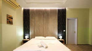 A neatly made bed with white linens, a rolled towel, and two bedside lamps. - Azzurra Studio 03 in Durrës (Durrës)