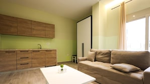 A modern living room with a white coffee table, a beige sofa, and wooden cabinets. - Azzurra Studio 03 in Durrës (Durrës)