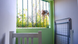 A room with a green wall, a window with metal bars, and a white chair. - Azzurra Studio 01 in Durrës (Durrës)
