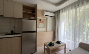 Eine moderne Küche mit integriertem Kühlschrank und einer Essecke, ein Tisch ist für zwei Personen gedeckt.