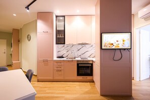 Une cuisine moderne avec un dosseret en marbre, des armoires en bois et un four encastré.