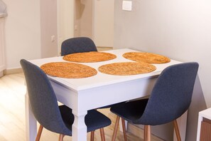 Ett matbord med fyra vävda bordstabletter och fyra mörka stolar.