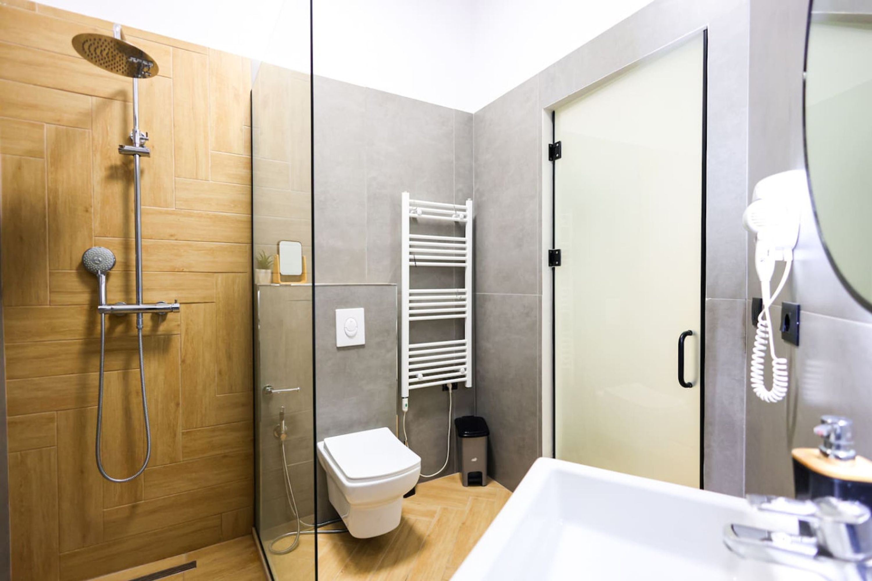 Et moderne badeværelse med bruser, toilet og vask.