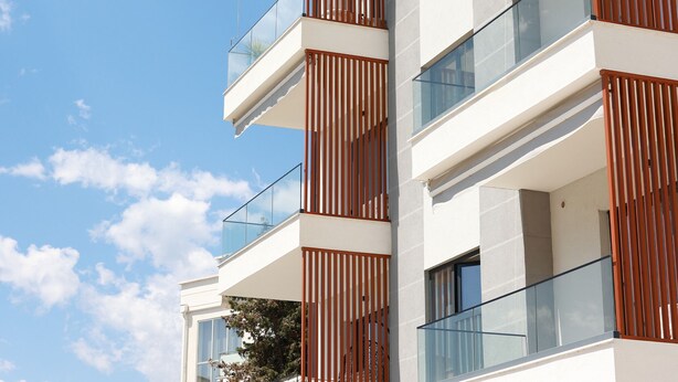 A multi-story building with balconies, large windows, and a clear sky. - Stay By Ilvesta Potam (Himarë)
