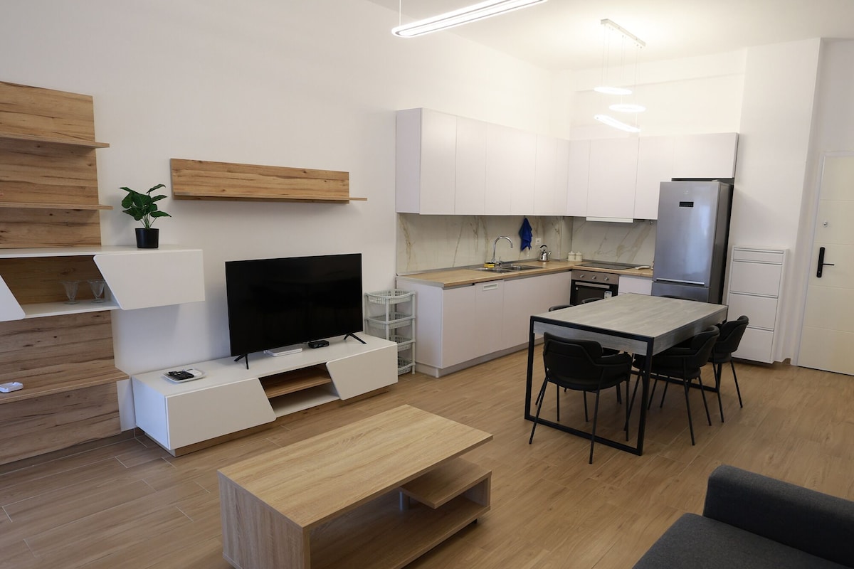 A modern kitchen with white cabinets, a built-in oven, and a refrigerator.