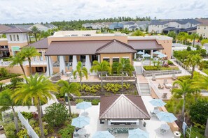 A hotel with a central courtyard, outdoor seating, and a pool area. - 5Bd Villa Private Pool   Spa at Solara Resort 1820 (Kissimmee)
