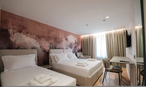 Una habitación de hotel con dos camas, un escritorio, una silla y un televisor.
