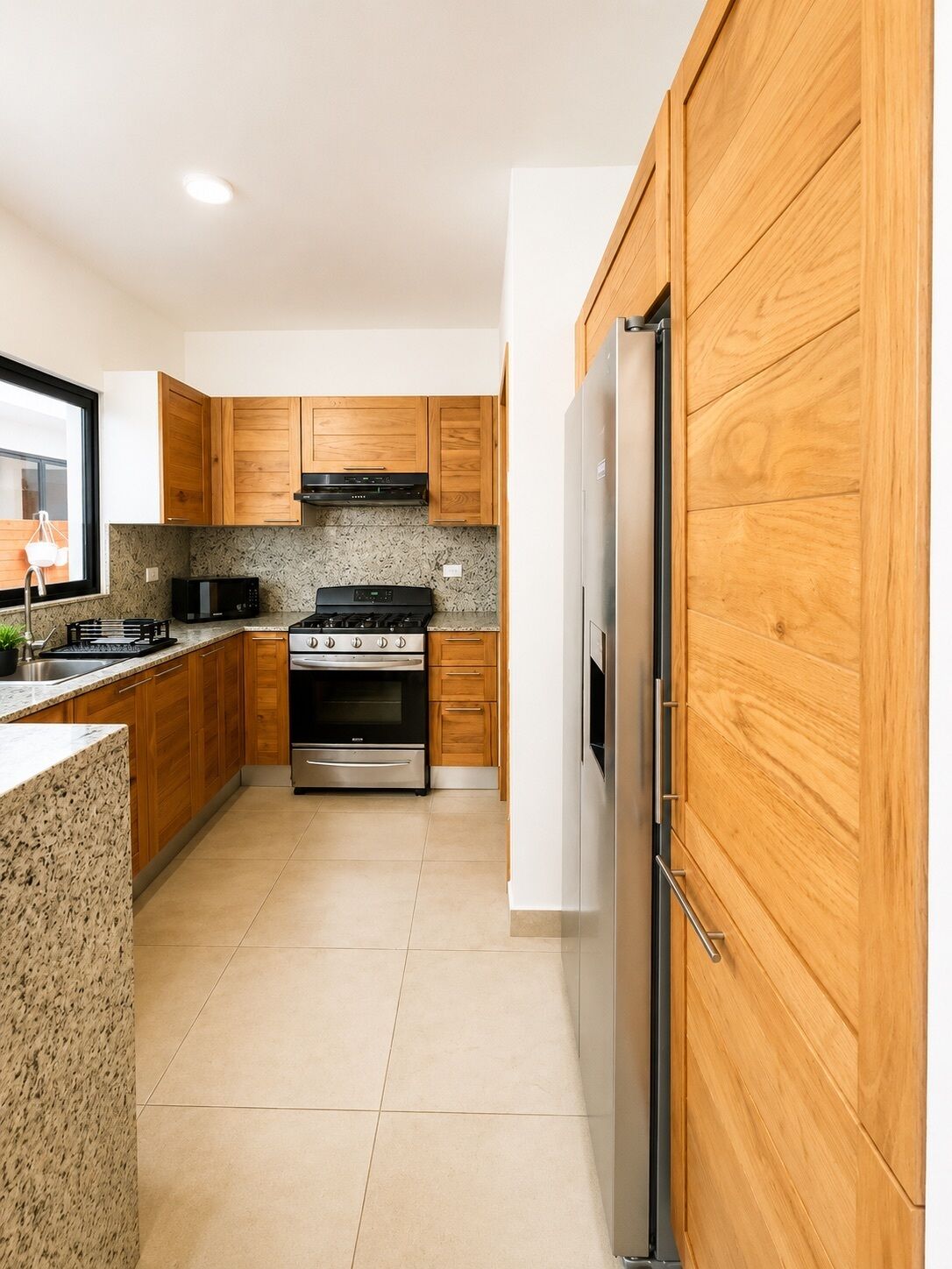 A modern kitchen with wooden cabinets, stainless steel appliances, and a granite countertop.