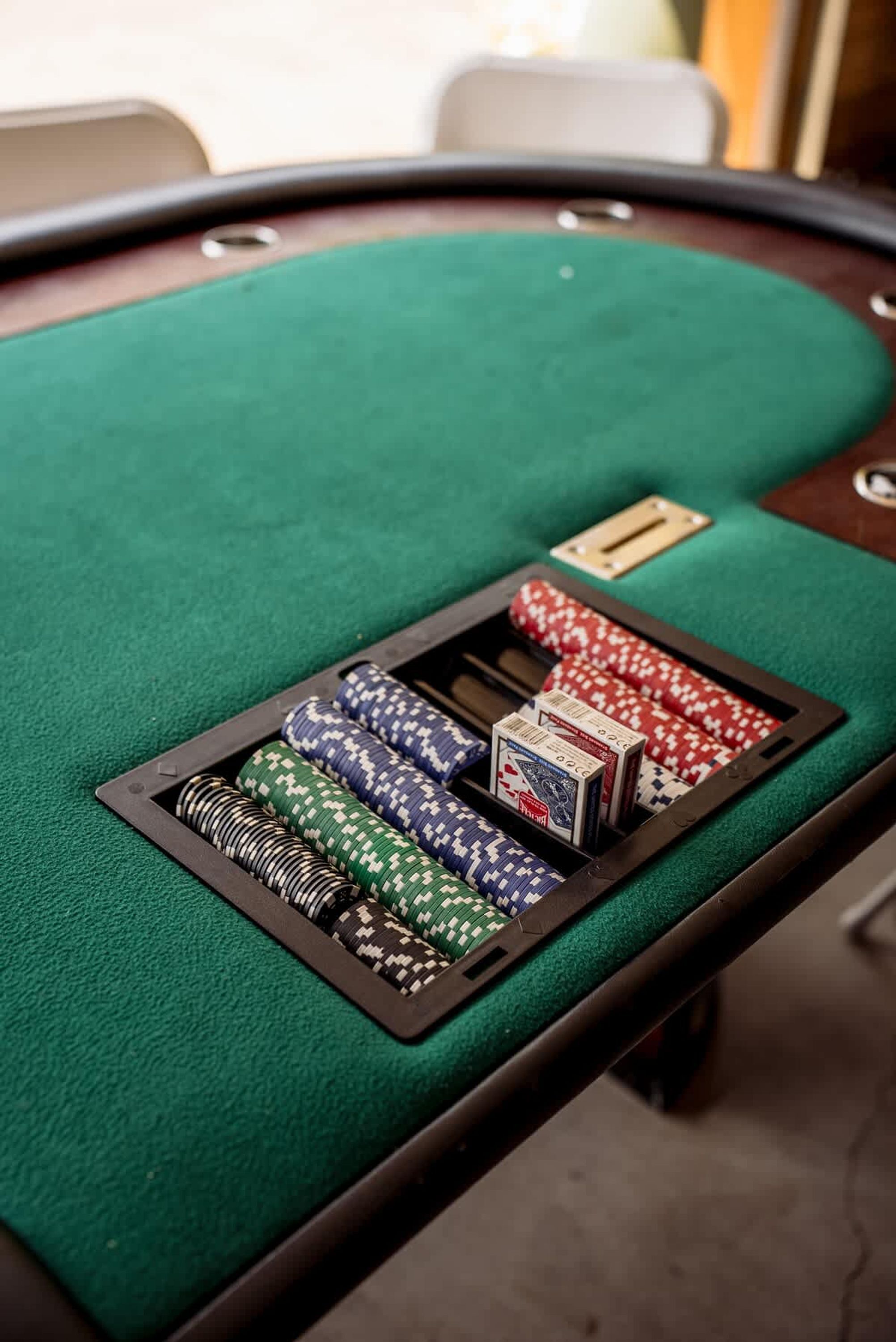 A green felt table with poker chips and cards.