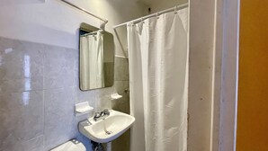Ein Badezimmer mit Waschbecken, Spiegel und Duschvorhang.