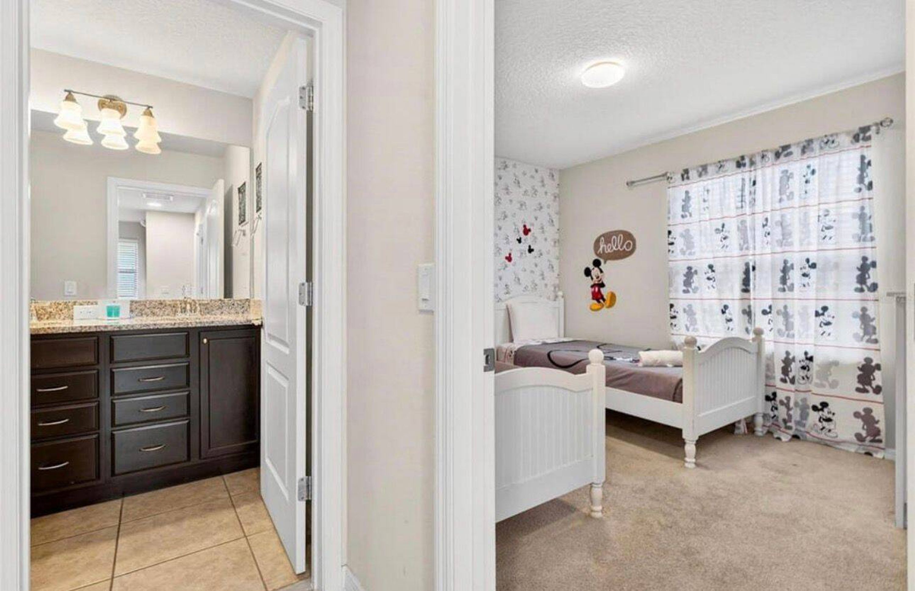 Ein Schlafzimmer mit einem Bett, einem Nachttisch und einer Wand mit Mickey-Mouse-Motiven.