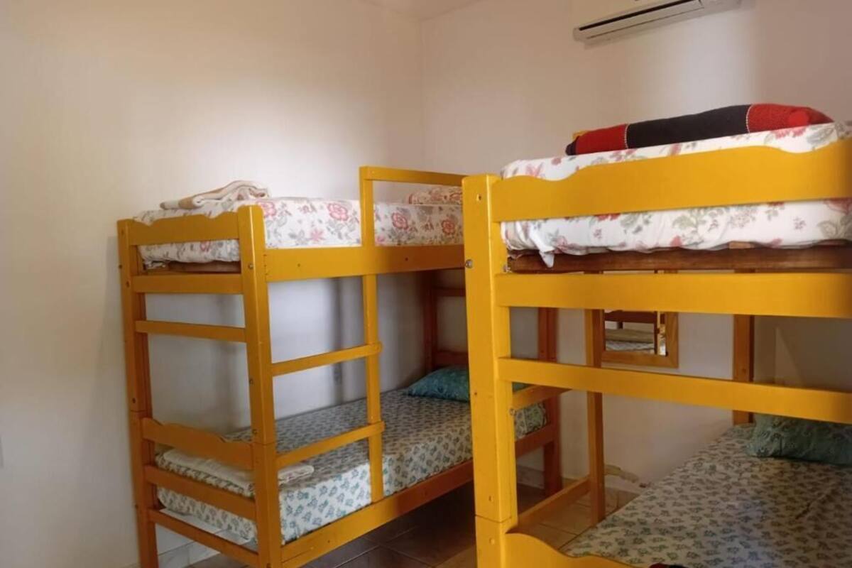 A room with two bunk beds, each with a mattress and pillow.