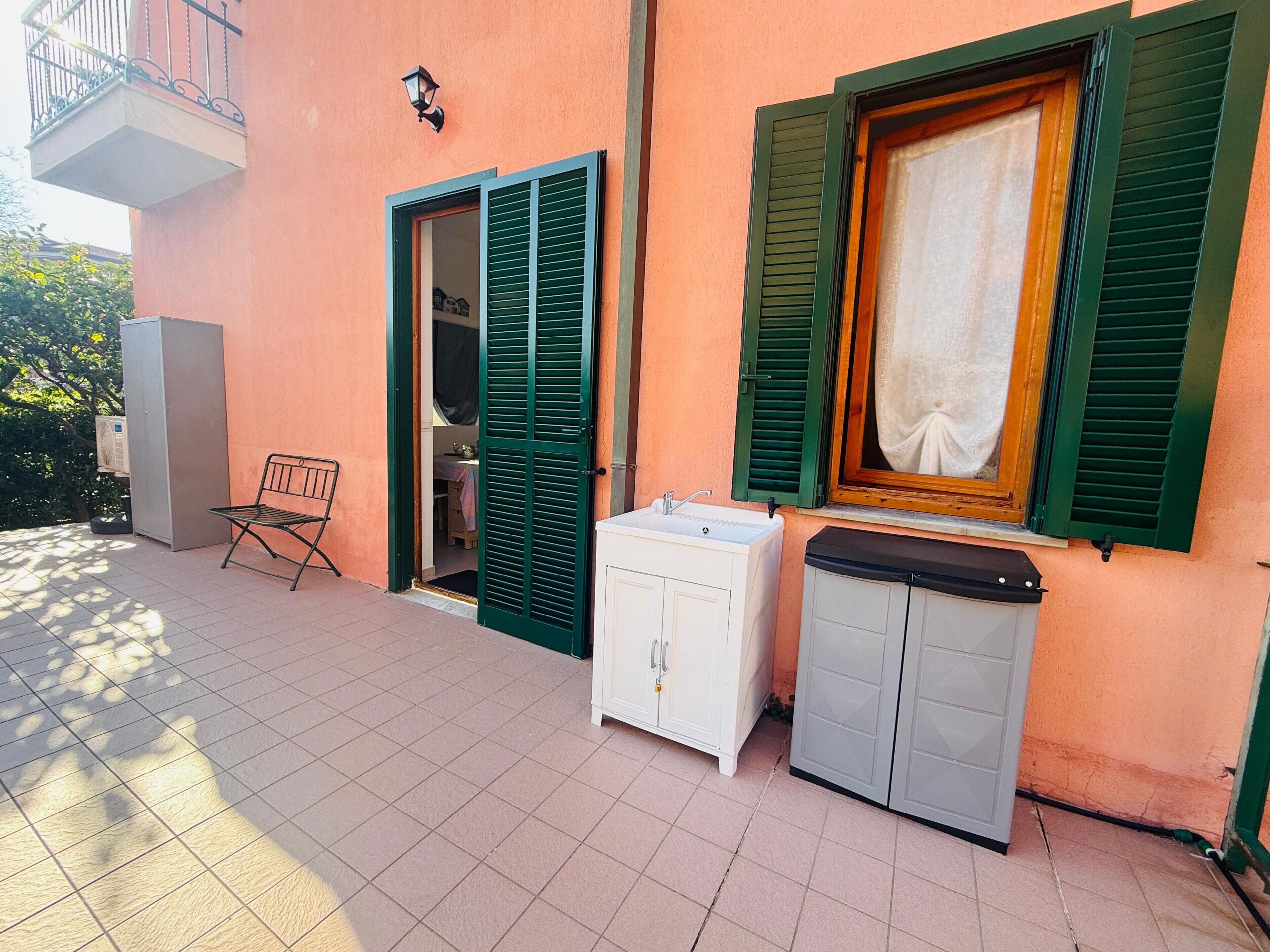 Une pièce avec une fenêtre, un lavabo, un placard et une chaise.