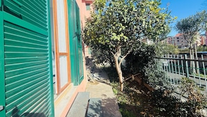 A building with green shutters, a tree, and a fence. - Terrazza vicino alla spiaggia in centro (Marina di Andora)