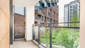 A balcony with a view of neighboring buildings and a garden. - Malila Apartments Cracow Rakowicka 254 (Kraków)