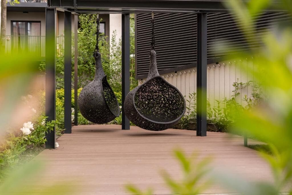 A covered outdoor area with a wooden deck and hanging planters.