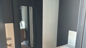 Een badkamer met toilet, spiegel, wastafel en douche.
