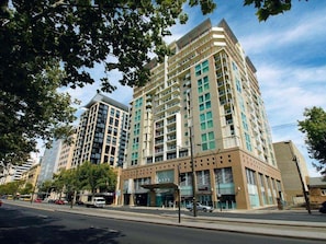 A multi-story hotel with a modern design, featuring a prominent entrance with a covered area and a visible parking lot. - Cozy & Affordable in CBD - Free Wine (Adelaide)