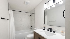 Un bagno moderno con doccia, WC e lavabo.