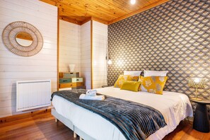 Ein ordentlich eingerichtetes Schlafzimmer mit Bett, Nachttischen, einem Spiegel und einer Heizung.