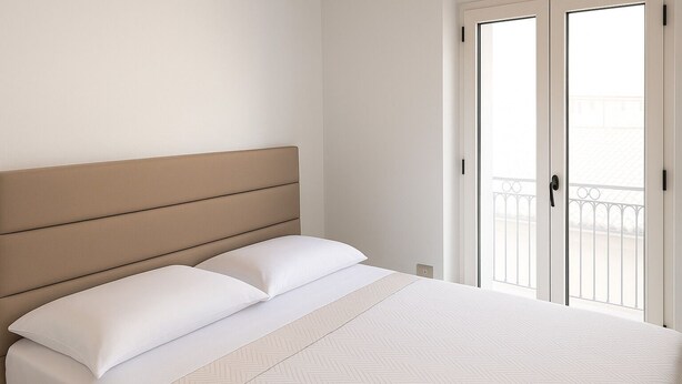 A bedroom with a bed, white bedding, a headboard, and a balcony with a railing. - Appatamenti ABR Corso - Apartment with View and Balcony (Le Castella)