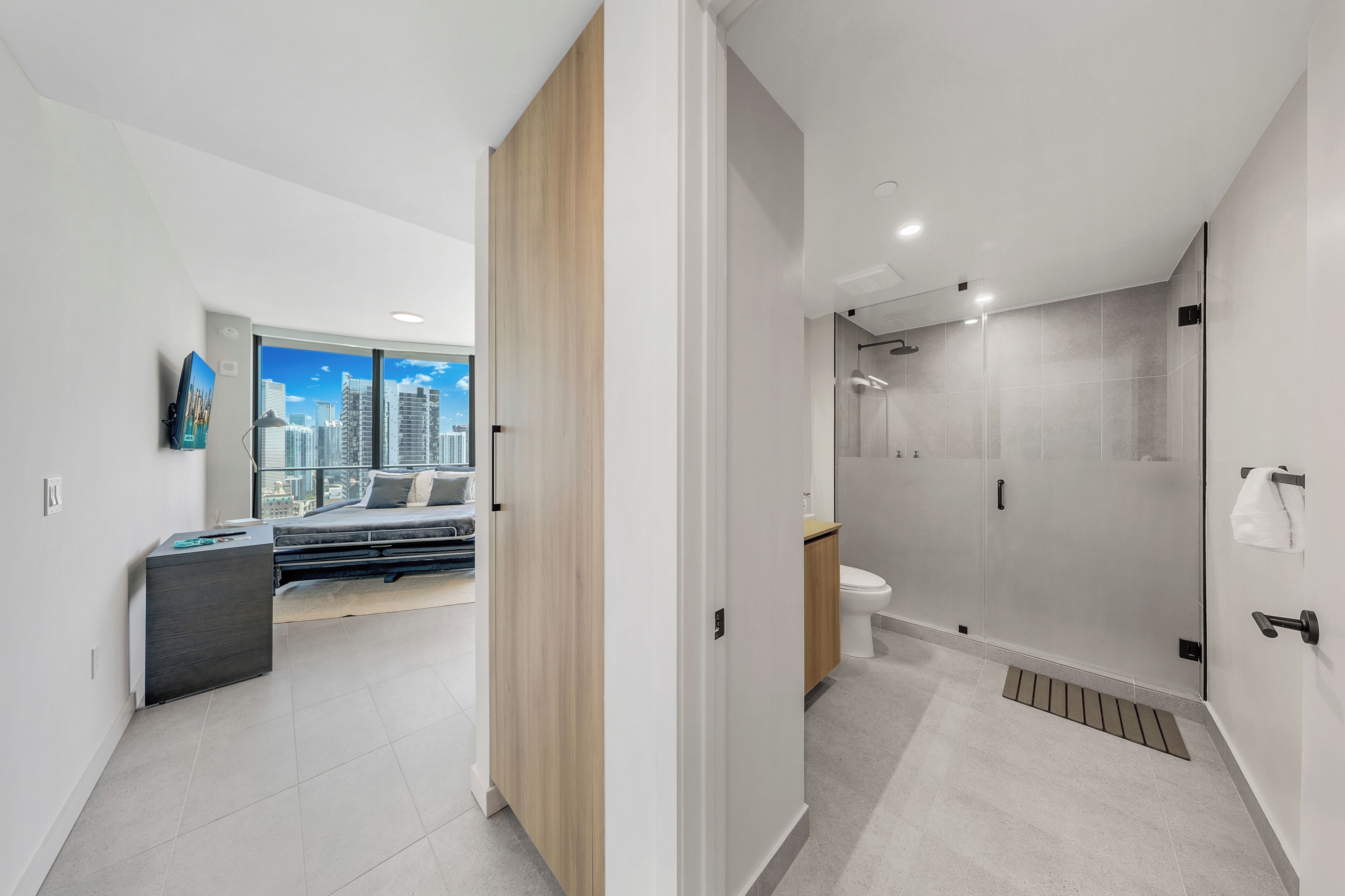 Un baño moderno con cabina de ducha de vidrio, inodoro y lavamanos.