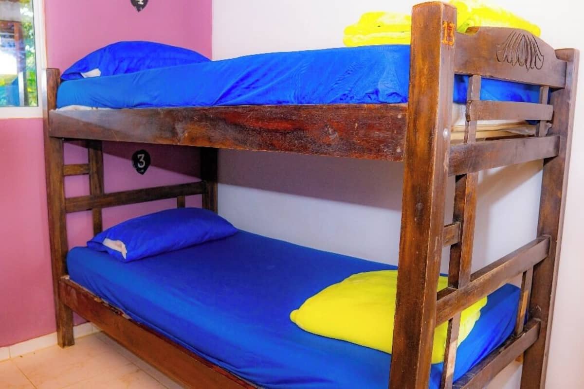 A bunk bed with blue bedding and a yellow pillow.