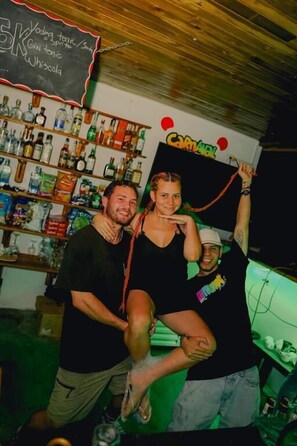 Un bar avec des étagères remplies de bouteilles d’alcool, un menu écrit à la craie et une enseigne sur laquelle on peut lire « CARAVAN ».