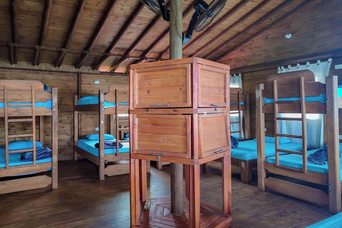 A cabin with bunk beds, wooden walls, and a ceiling fan.