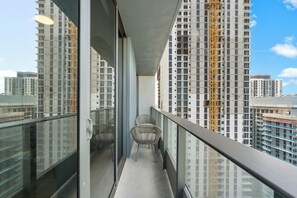 Ein Balkon mit Blick auf hohe Gebäude, darunter auch ein Neubau.