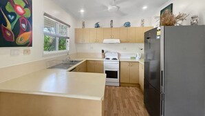 Una cucina moderna con isola centrale, piano cottura e frigorifero.
