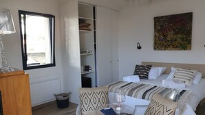 Une chambre à coucher avec un lit, une table de chevet, une lampe et un tableau au mur.