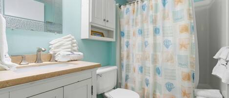 A bathroom with a toilet, sink, and cabinet.