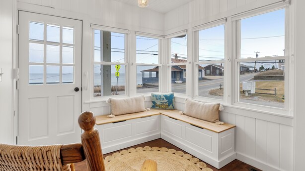 Habitación de esquina con banco integrado, ventanas amplias y vistas al exterior.