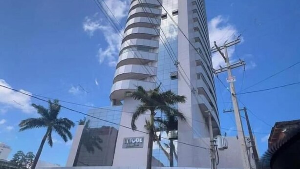 Un grand hôtel moderne à l’architecture cylindrique, dont la façade est ornée d’une grande enseigne indiquant « HÔTEL ».