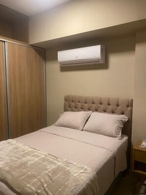 A bedroom with a bed, a wardrobe, and an air conditioning unit. - Flat Unique Belém para 2 pessoas (Belem)