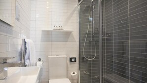 Un baño moderno con bañera, inodoro y ducha con mampara de vidrio.
