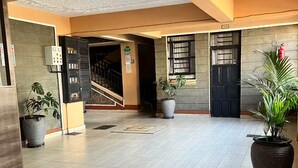 Un hall d’entrée spacieux, doté d’un sol carrelé, d’un escalier et de plantes en pot.